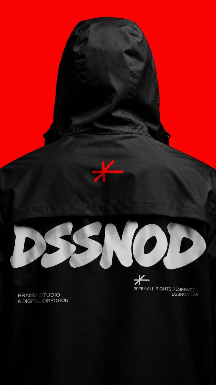 The back of a black hooded jacket with a large white DSSNOD logotype on a red backdrop