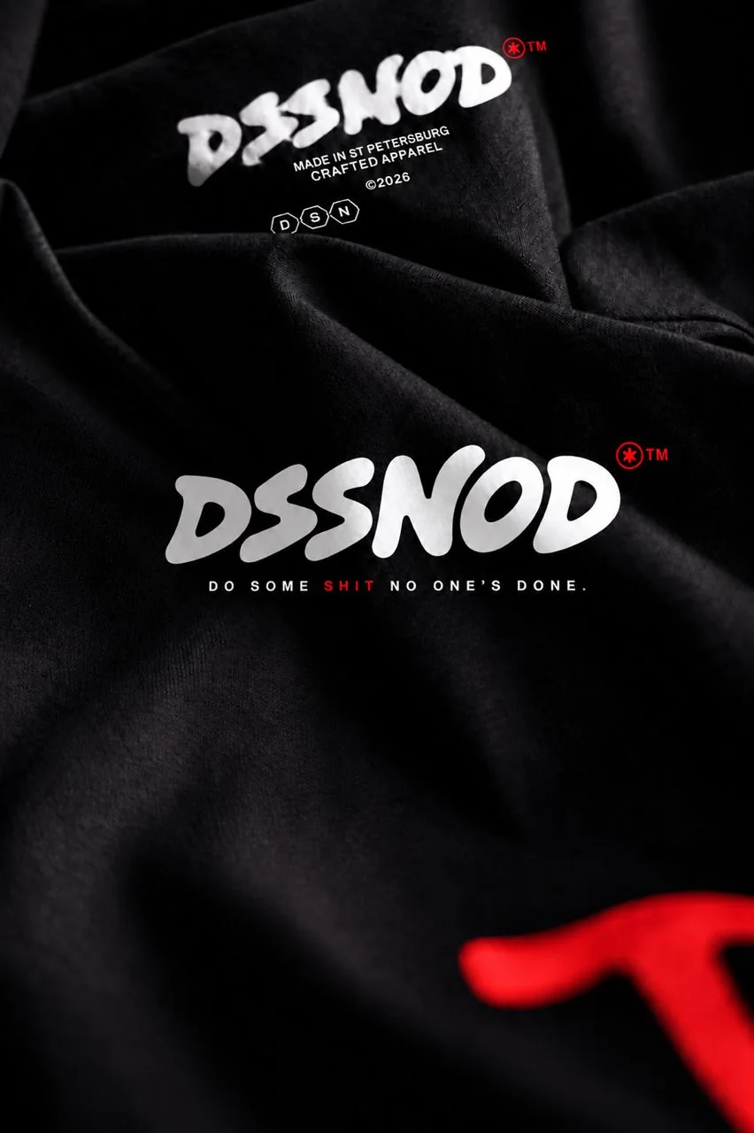 White DSSNOD logotype printed inside the neck of a black t-shirt
